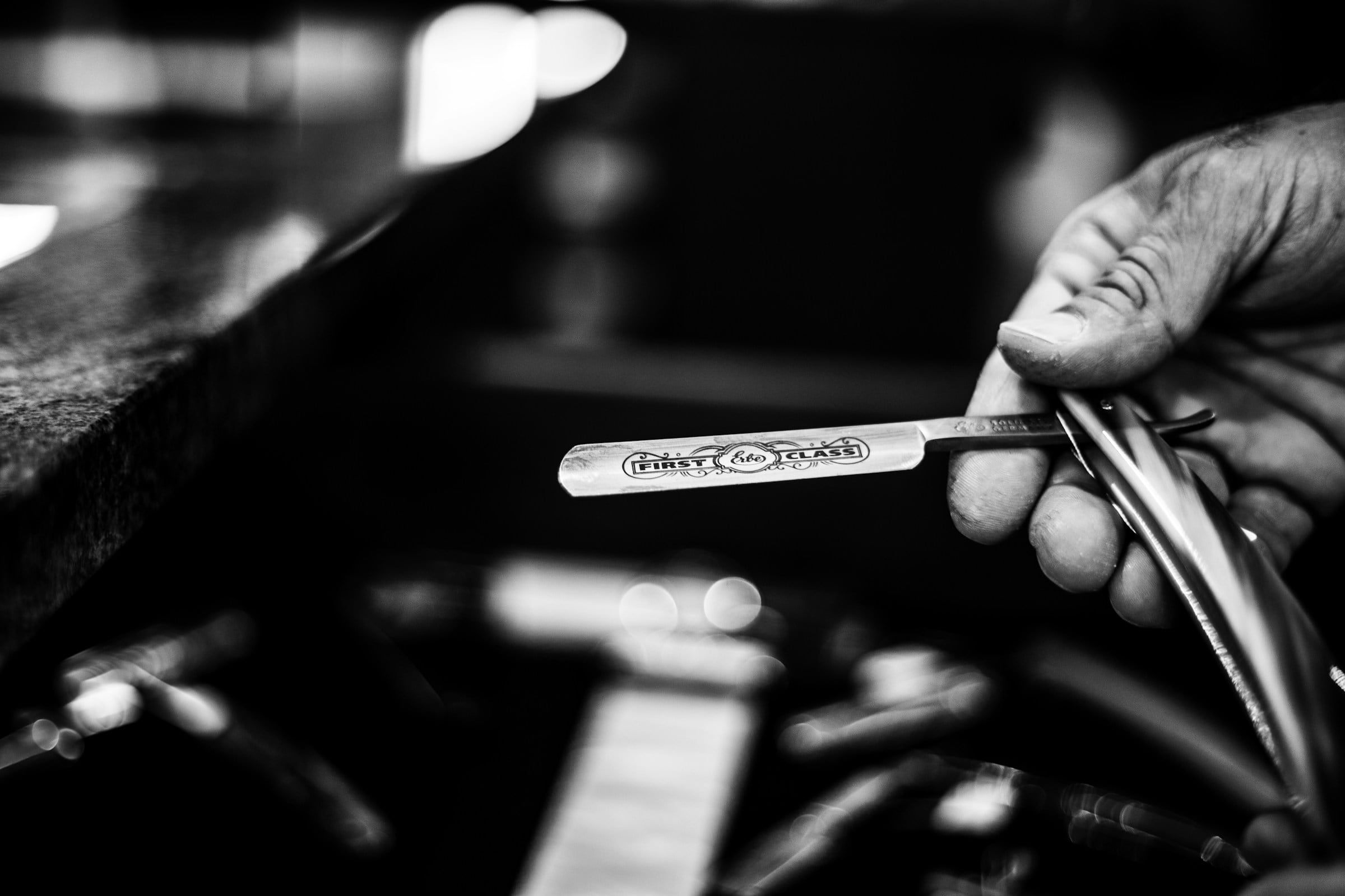 Hand mit Rasiermesser am Barber-Platz
