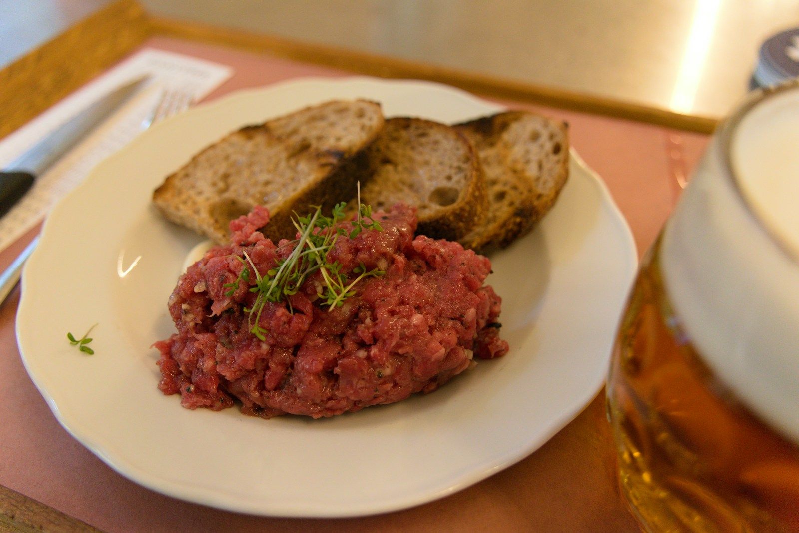 Rindstatar mit Schnittlauch und Toastbrot auf einem weissen Teller