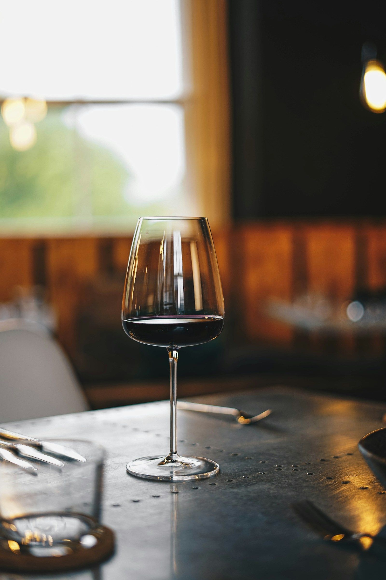 Rotwein wird in ein Glas eingeschenkt